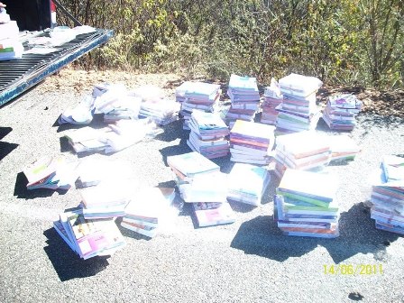 Centenas de livros escolares novos são encontrados em terreno baldio. FOTOS!